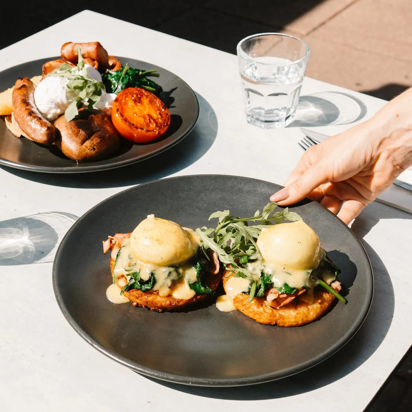 Eggs Benedict on potato rosti with rocket, served outdoors