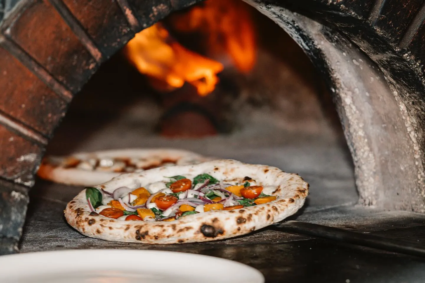Neapolitan pizza baking in a wood-fired oven